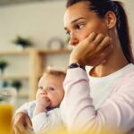 A mother holds her young child close, her expression thoughtful and concerned—capturing the emotional weight of parenthood and the need for support during challenging moments.