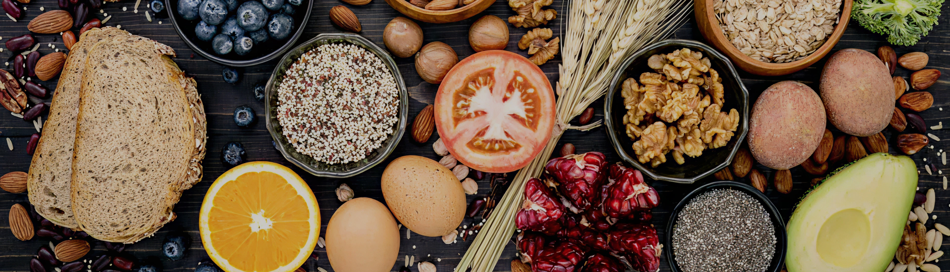 An overhead view of nutrient-rich whole foods including fruits, grains, nuts, seeds, eggs, and vegetables—representing balanced nutrition, mindful eating, and the foundation of holistic health.