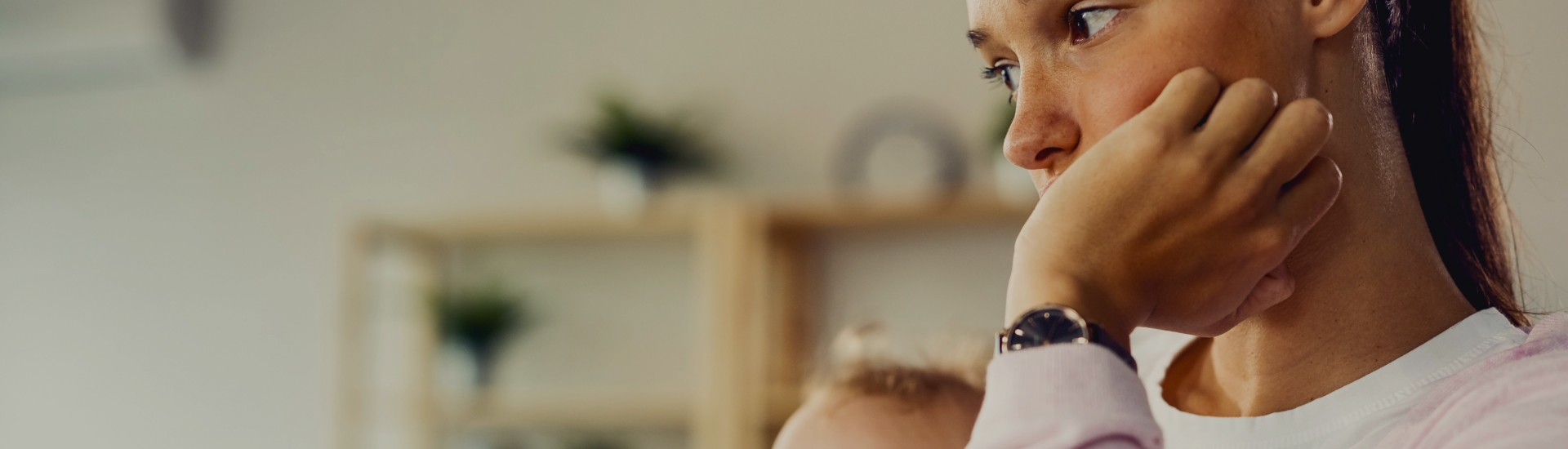 A mother holds her young child close, her expression thoughtful and concerned—capturing the emotional weight of parenthood and the need for support during challenging moments.