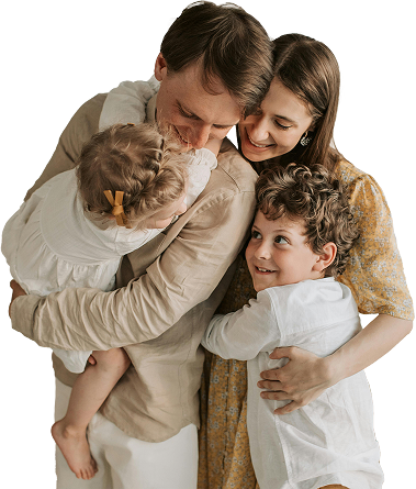 A joyful family of four embracing closely, with two smiling children held by their loving parents, capturing warmth, connection, and family wellness.