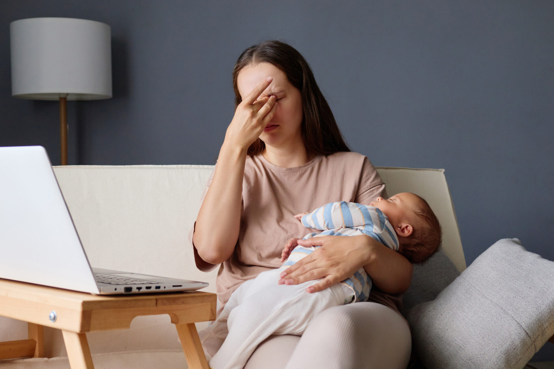 Mother experiencing emotional overwhelm while holding her baby, representing the need for therapy for perinatal depression in Edmonton at Spring Integrative Wellness.